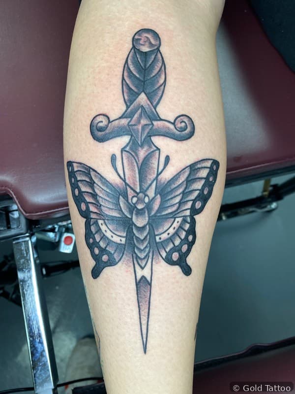 Dagger and moth tattoo on a forearm by Nathan at Gold Tattoo, 1506 S Las Vegas Blvd, Unit 3