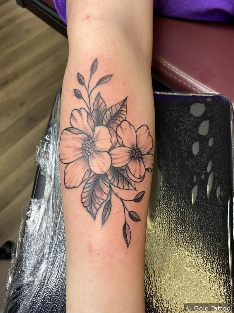 Fine-line flower tattoo on a forearm by Nathan at Gold Tattoo, 1506 S Las Vegas Blvd, Unit 3